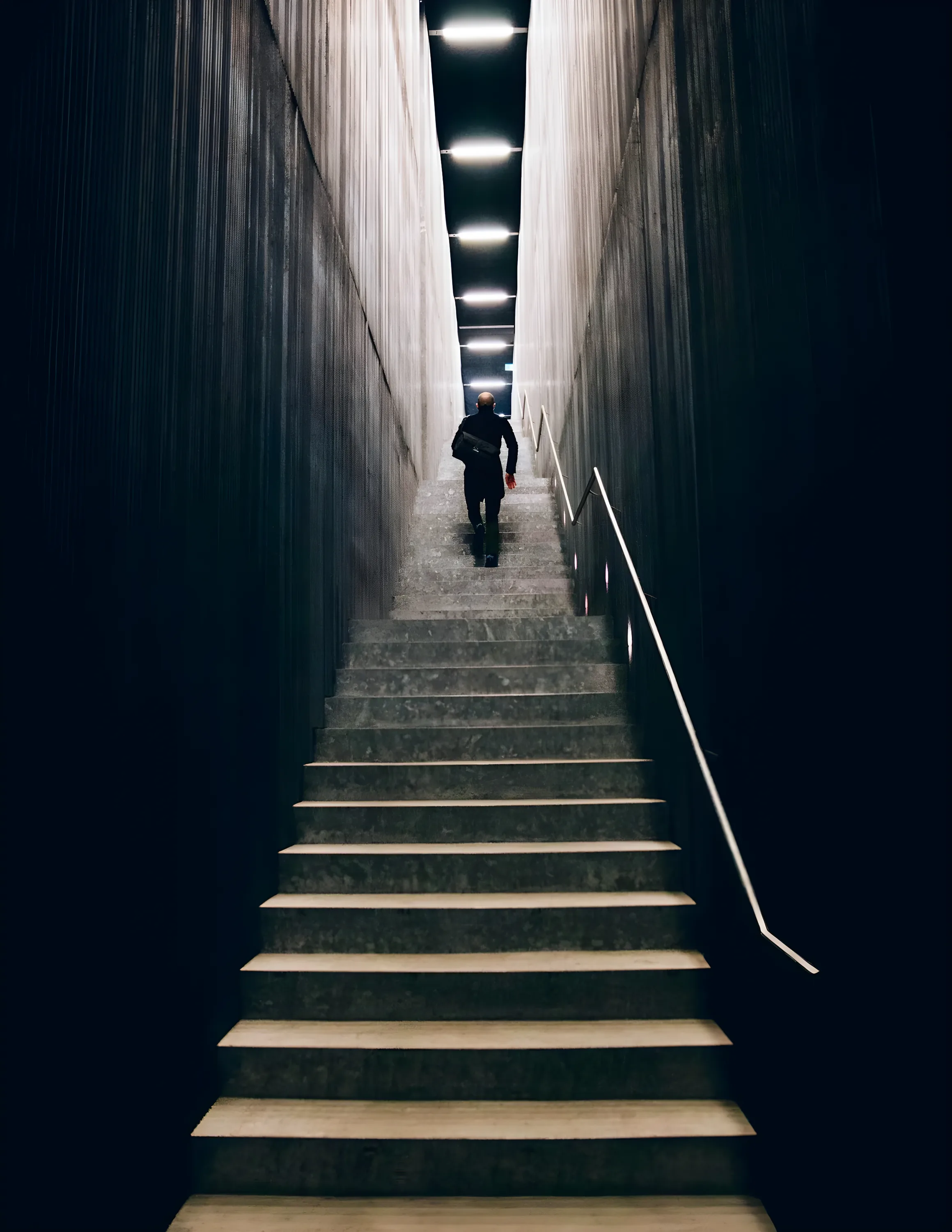 A person walking up a long staircase
